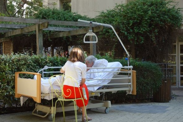 bénévole accompagnant une patiente au jardin